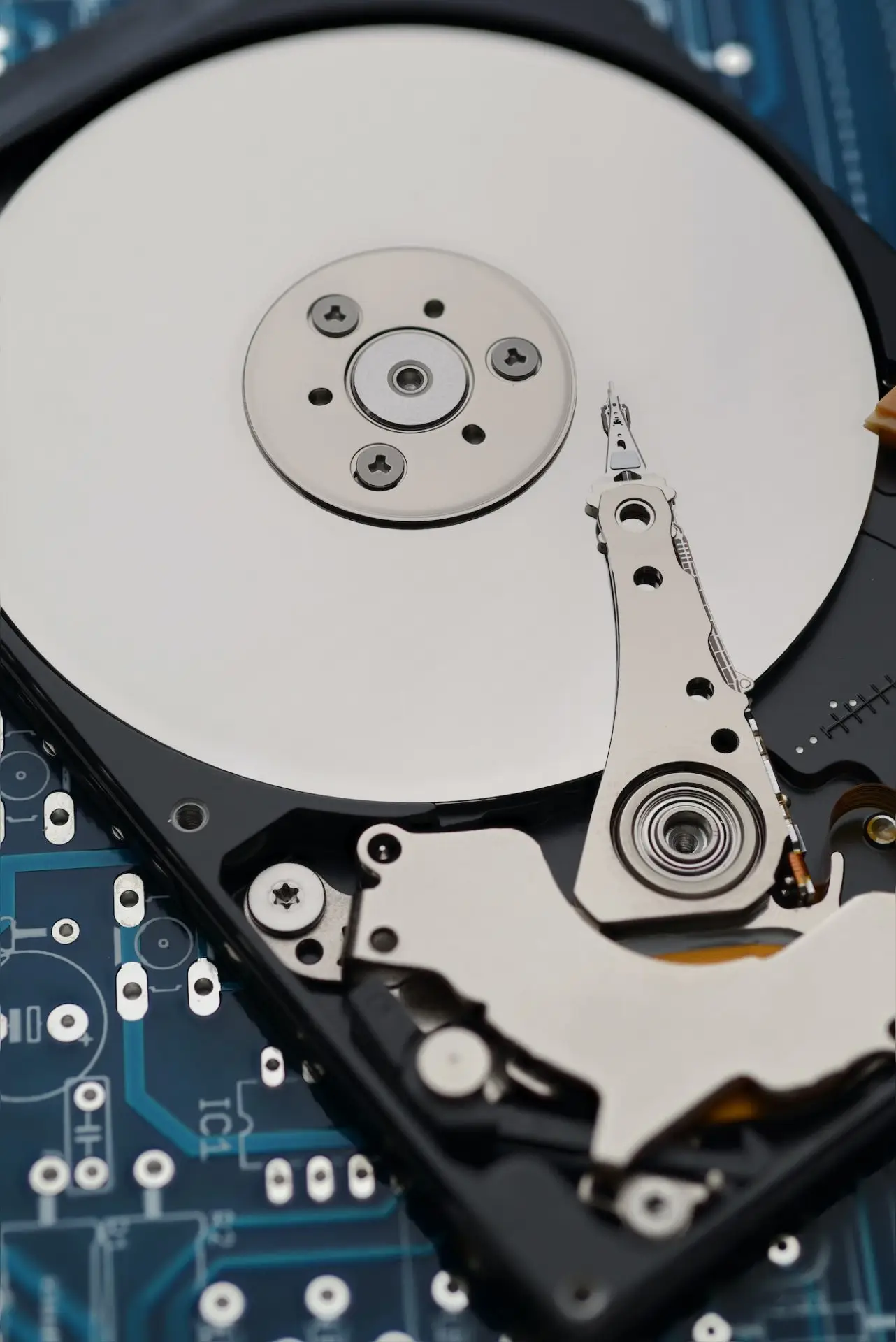 Opened hard drive showing the platter and read-write head arm, the parts that fail in most hard drive symptoms